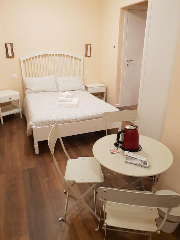 1 dormitorio con cama, mesa y espejo en Glam Resort G H O S T E L, en La Spezia