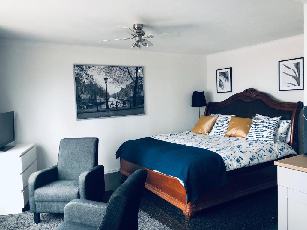 een slaapkamer met een bed en een stoel bij Casa Blanca Zandvoort in Zandvoort