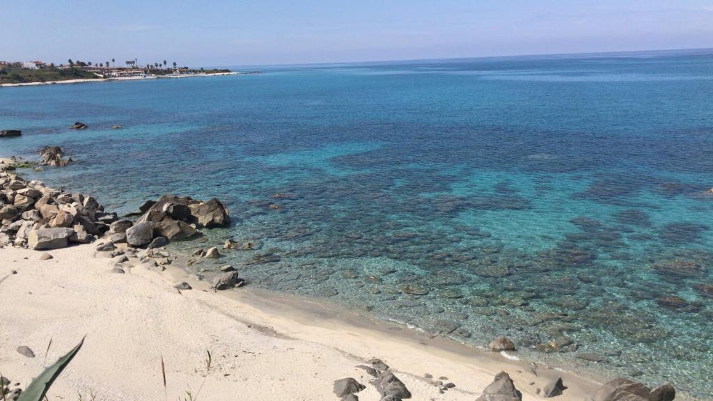 uma vista para uma praia com rochas e água em Villa sul mare em Briatico