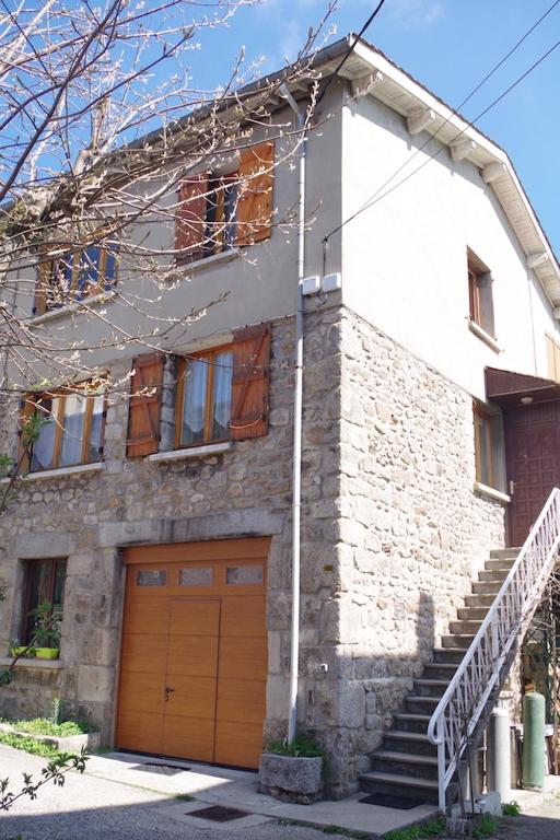 une maison en briques avec un garage et un escalier dans l'établissement Sur le plateau - Logement indépendant St Genest Malifaux, à Saint-Genest-Malifaux