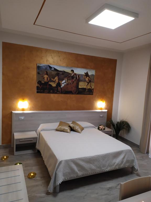 una camera da letto con un letto e un dipinto sul muro di B&B Domus Vettii a Pompei
