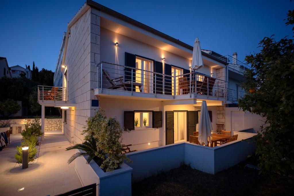 una casa con un balcón con sombrillas delante en Apartments ViLu, en Hvar