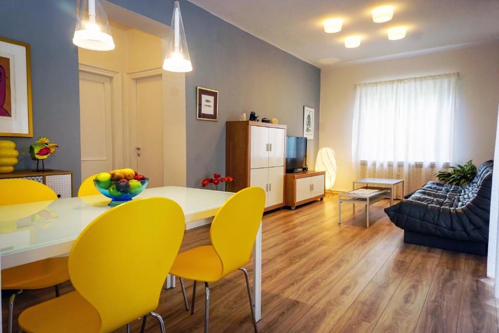 ein Wohnzimmer mit einem Esstisch und gelben Stühlen in der Unterkunft Apartment Nena in Zadar
