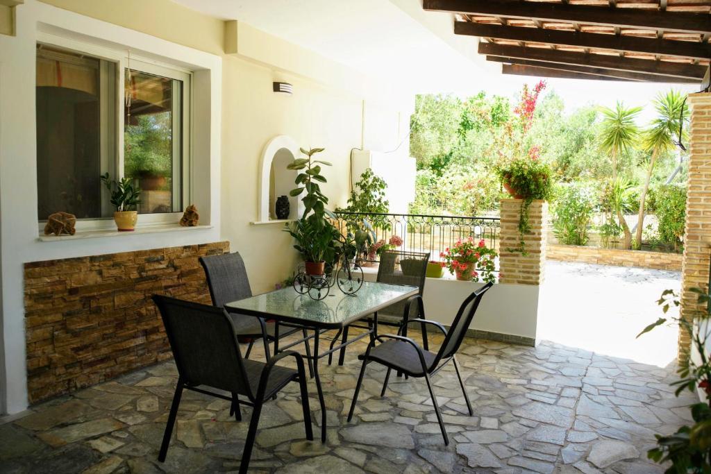 a patio with a table and chairs and a window at Petros Garden Ηouse in Gaïtánion