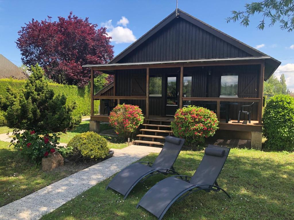 two chairs in front of a small cabin at Le Chalet du Lac - Domaine de la Goujonne in Saint-Sauveur-lès-Bray