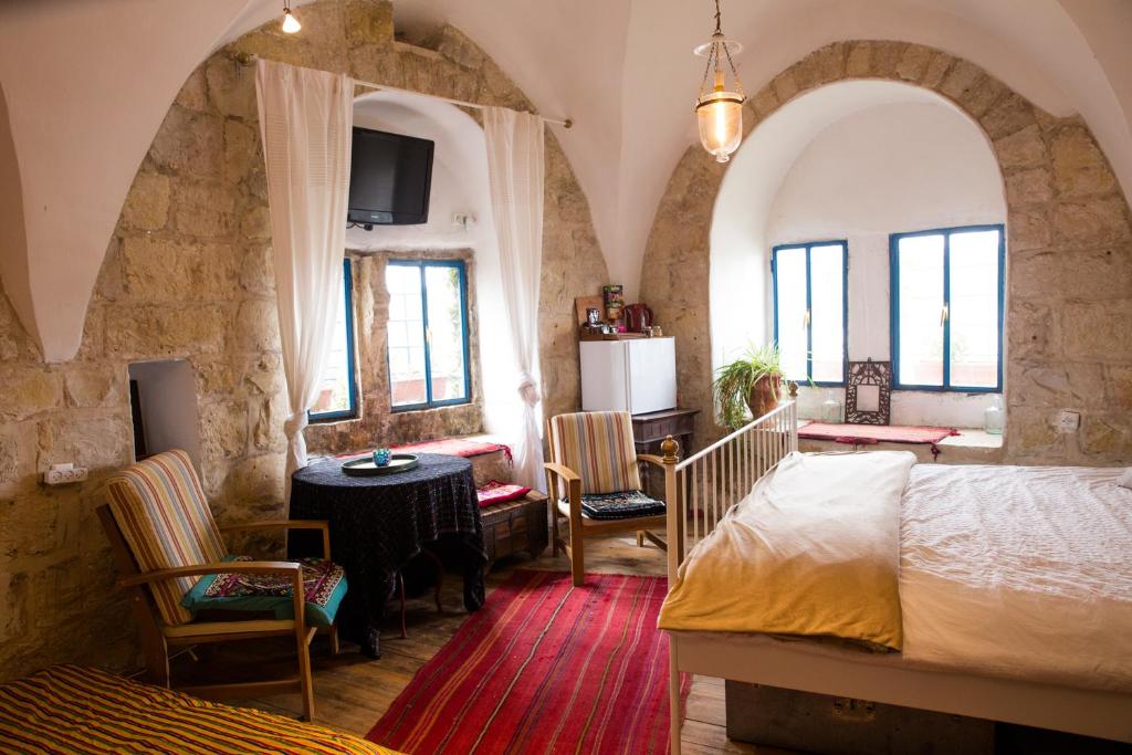 een slaapkamer met een bed en een tafel en stoelen bij Mikes Khan in Abū Ghaush