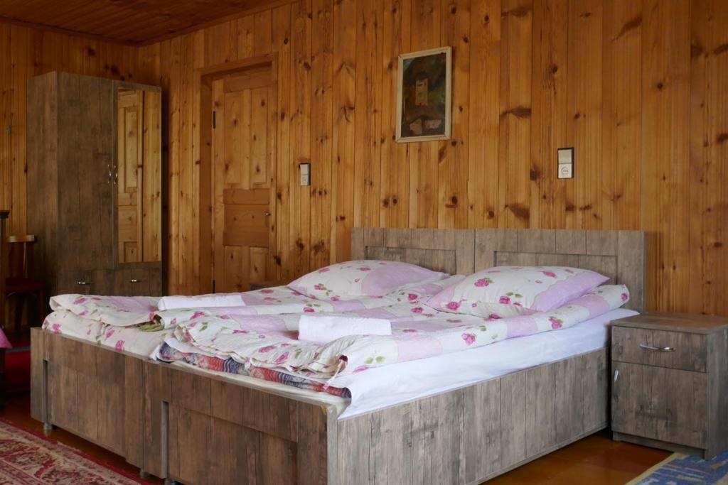 a bedroom with a large bed in a wooden wall at Lagami house in Mestia