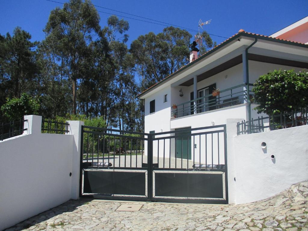 a white house with a gate in front of it at Casa do Vale - Seixas in Caminha