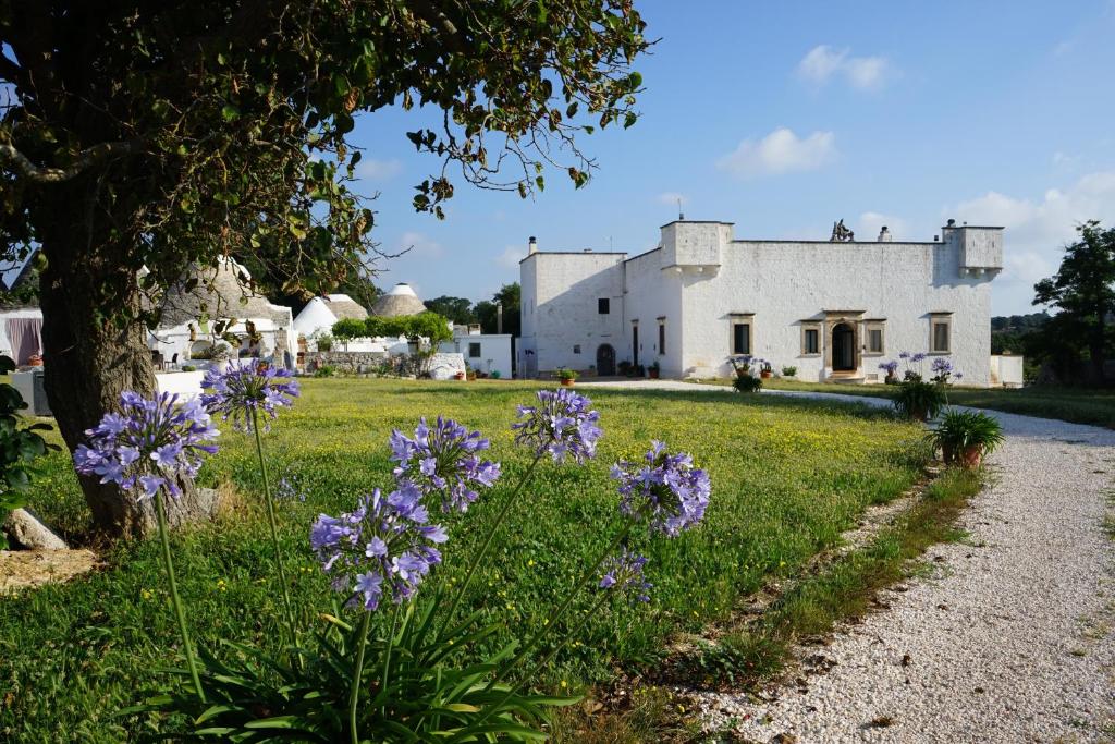 a field of purple flowers in front of a white building at Masseria Ferri in Ostuni