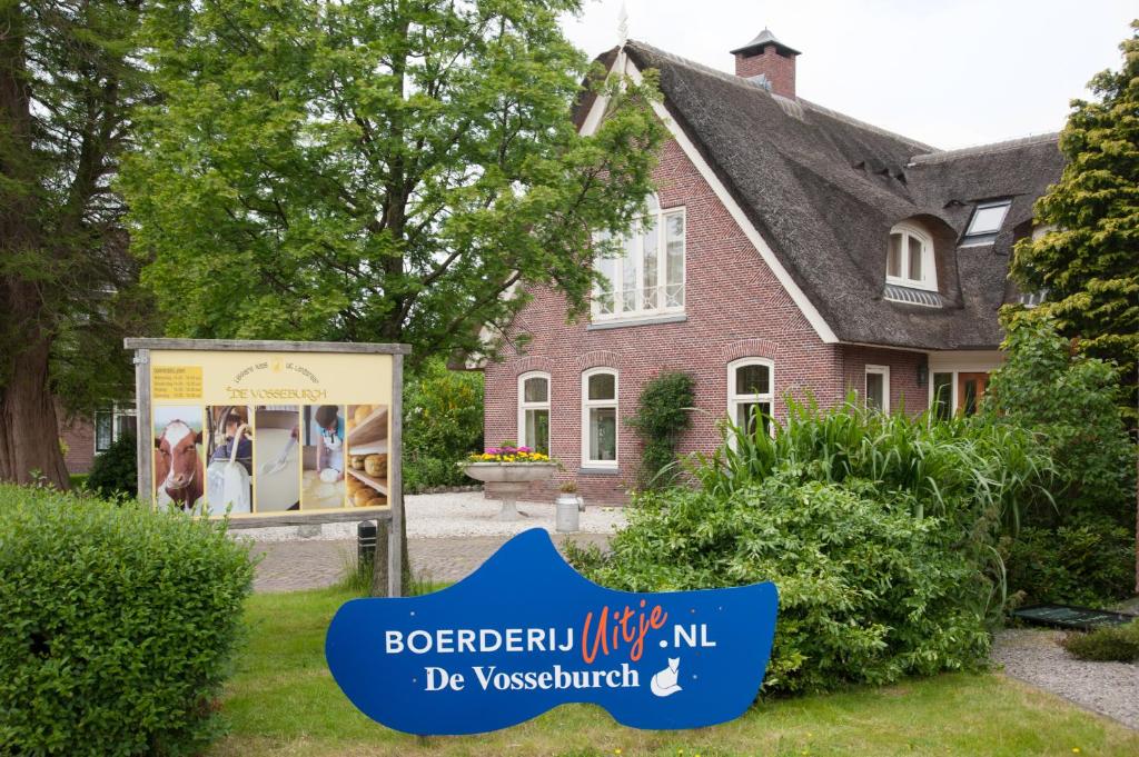 een huis met een bord ervoor bij Apartement De Vosseburch in Langeraar