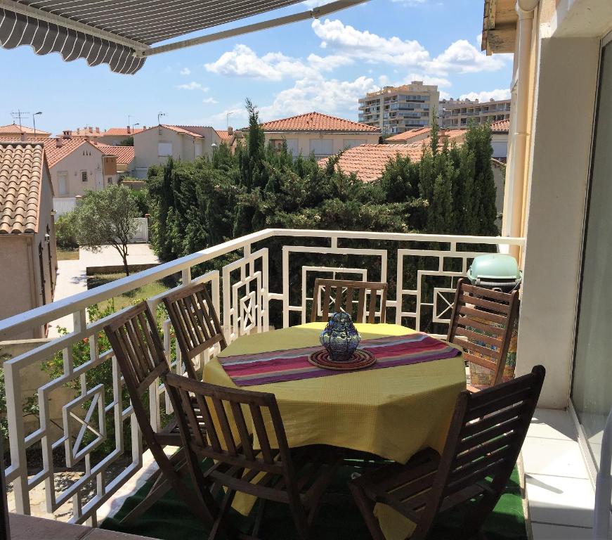 une table et des chaises sur un balcon avec vue dans l'établissement sci moliere, à Saint Cyprien Plage