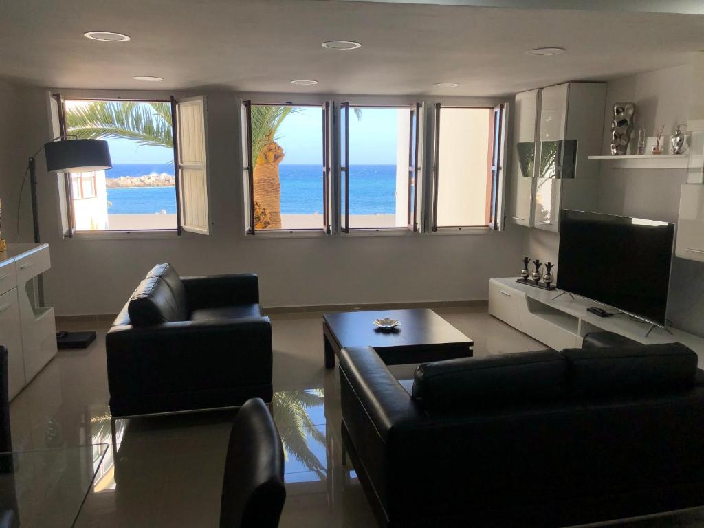 una sala de estar con sofás y TV y el océano en Luxury Sea House-Casa del Mar, en Santa Cruz de la Palma
