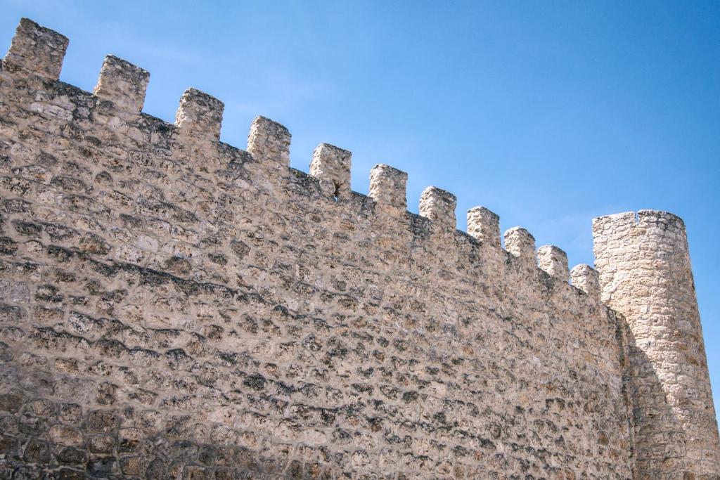 un grand mur en briques avec deux tours dans l'établissement CASAS LA MURALLA, à Peñafiel