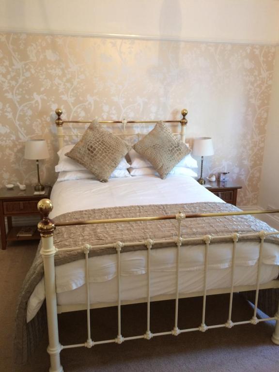 Ce lit se trouve dans un dortoir doté de 2 tables et de 2 lampes. dans l'établissement Baytree B&B, à Charlestown