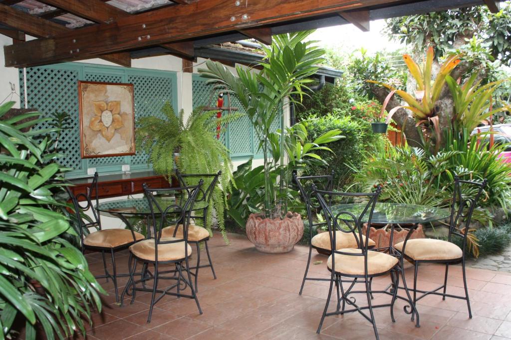 eine Terrasse mit einem Tisch, Stühlen und Pflanzen in der Unterkunft Tierra Magica B&B and Art Studio in San José