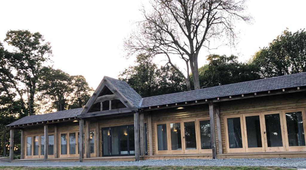 a building with windows and a black roof at Whitehall Estate Lodges in Winestead