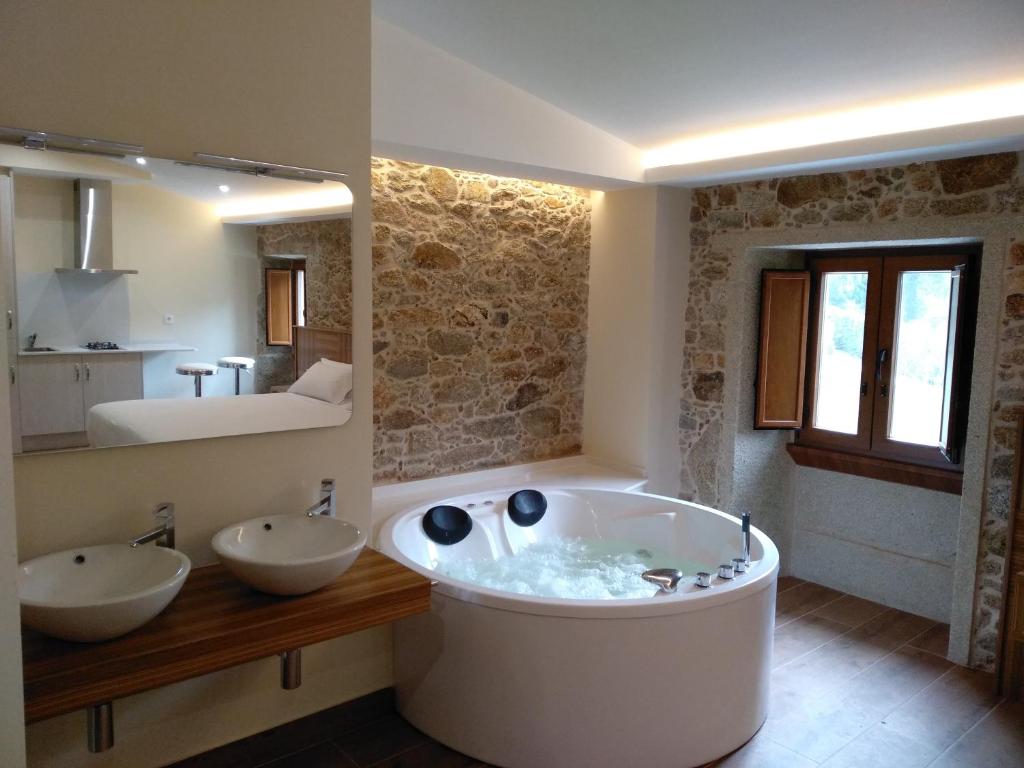 un ampio bagno con due lavandini e una vasca di VILAR DE LEMA a Muxia