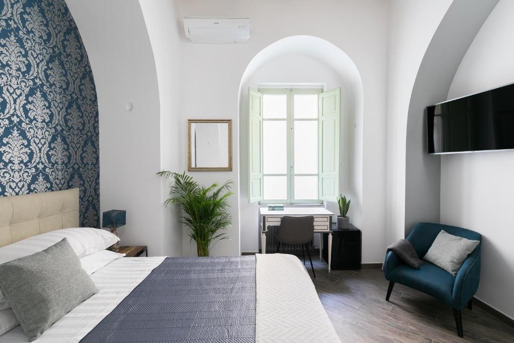 a bedroom with a bed and a desk and a tv at Horti Sallustiani Roma in Rome