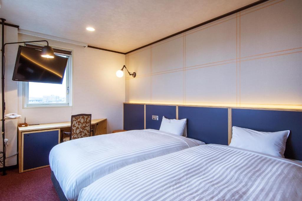 Postel nebo postele na pokoji v ubytování TsukubaNoYu Urban Hotel