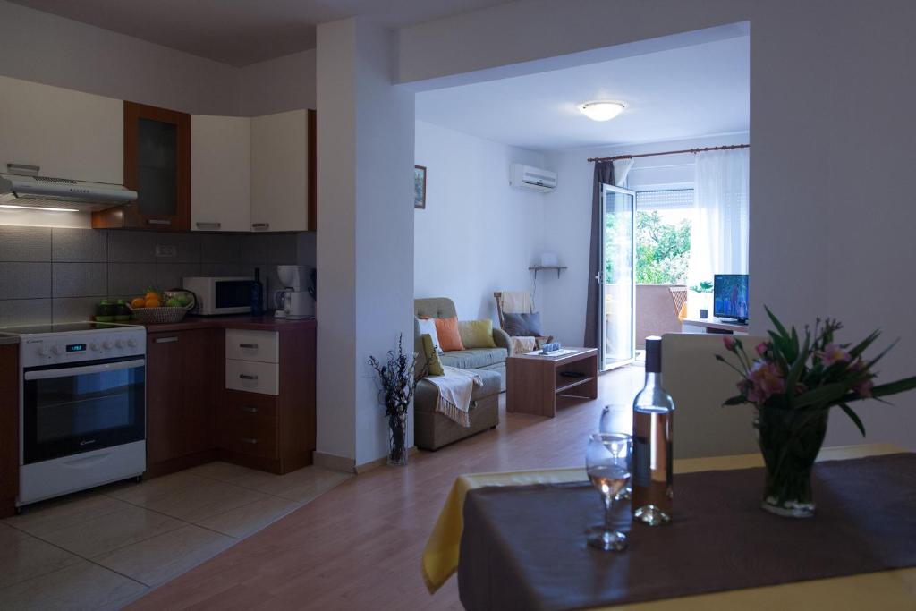 cocina y sala de estar con sofá y mesa en Apartment Helga en Ližnjan