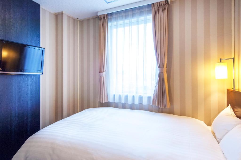 Postel nebo postele na pokoji v ubytování TsukubaNoYu Urban Hotel