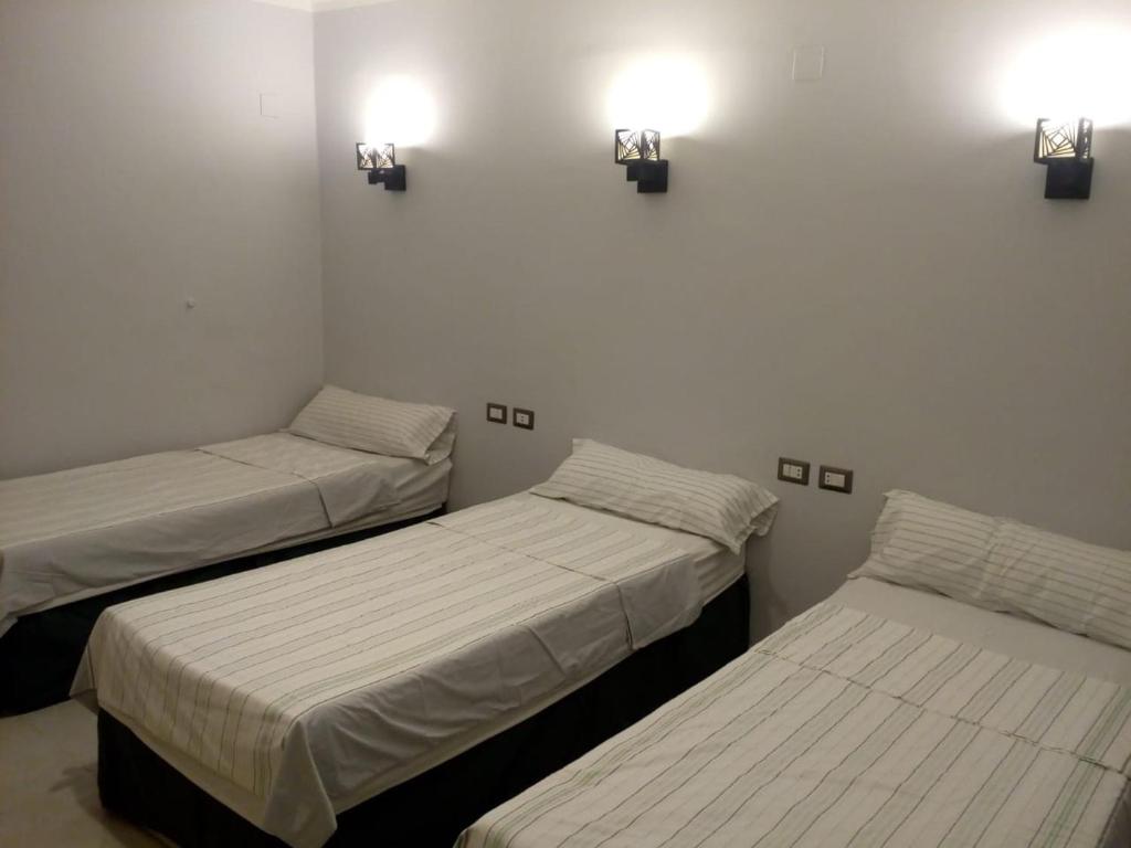 a room with two beds and two lights on the wall at Venus Hostel in Cairo