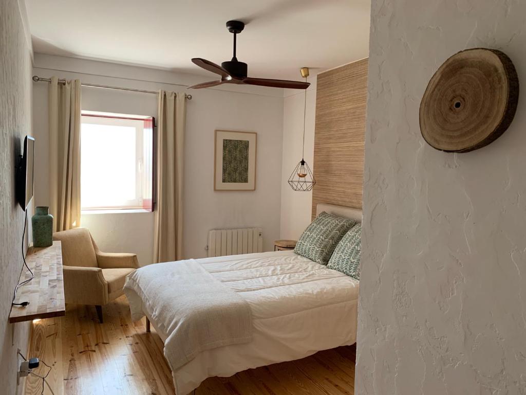 a bedroom with a bed and a ceiling fan at Monte Capitão Country house in Salvada