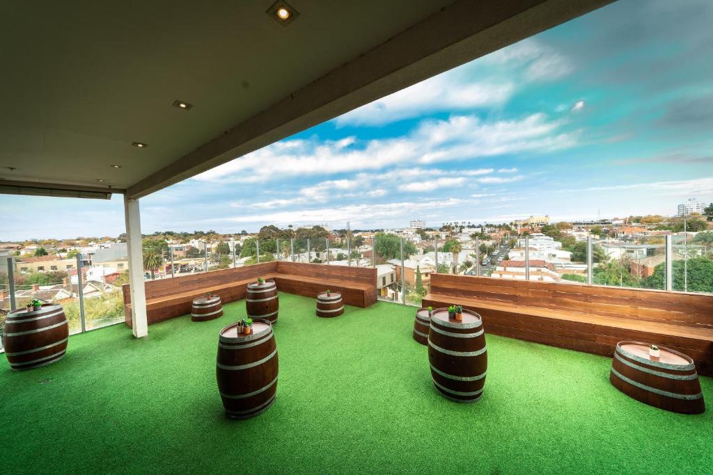 a balcony with stools and a view of a city at Summer House Melbourne Backpackers in Melbourne