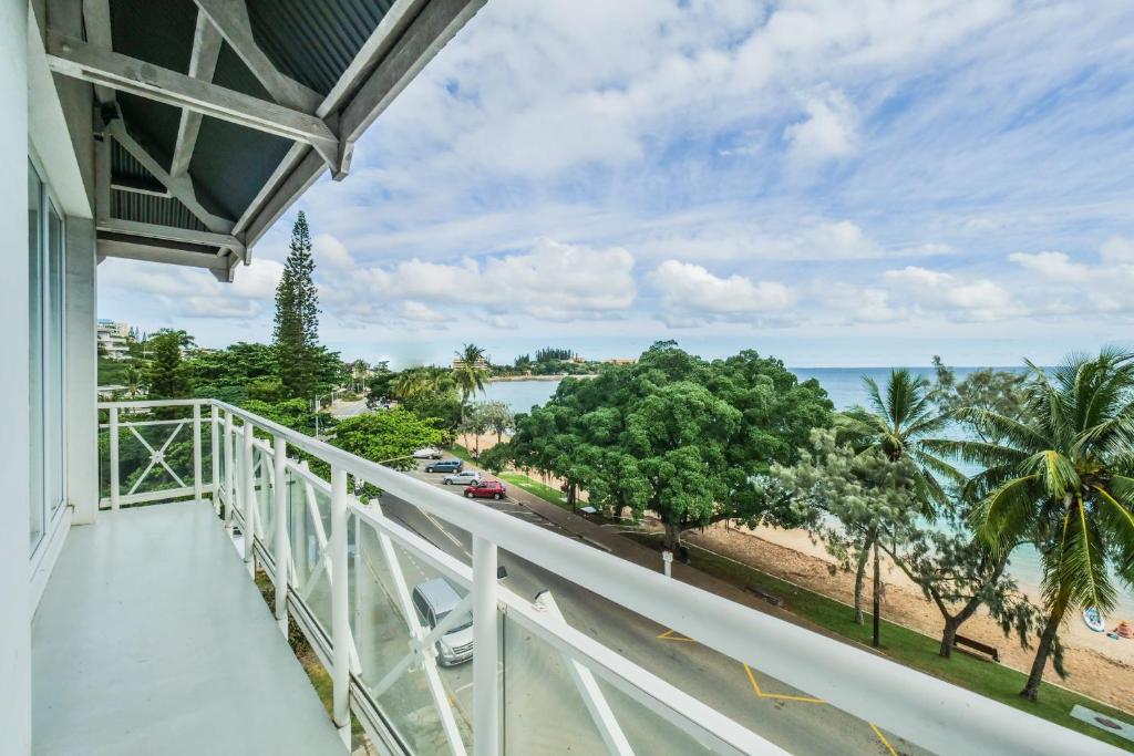 a balcony with a view of the beach and the ocean at Hotel Beaurivage in Noumea