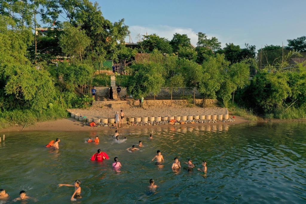 a group of people swimming in the water at Phong Nha Village House in Phong Nha