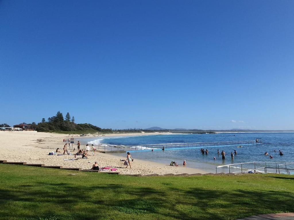 a group of people playing in the water at a beach at CHILL-OUT BEACHSIDE - Main Beach Forster in Forster