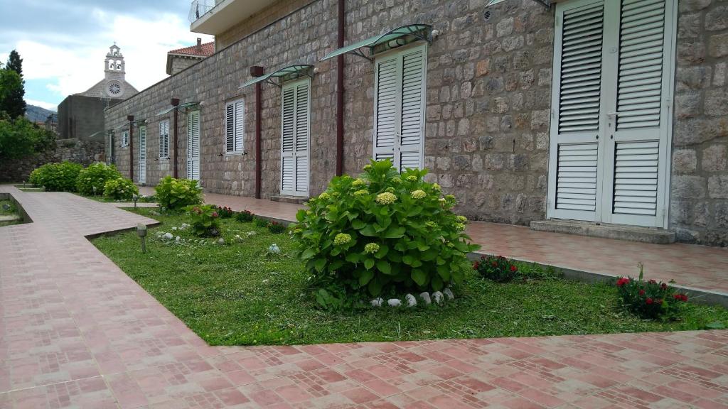 un arbusto en la hierba junto a un edificio de ladrillo en Guest House Eight Roses, en Dubrovnik