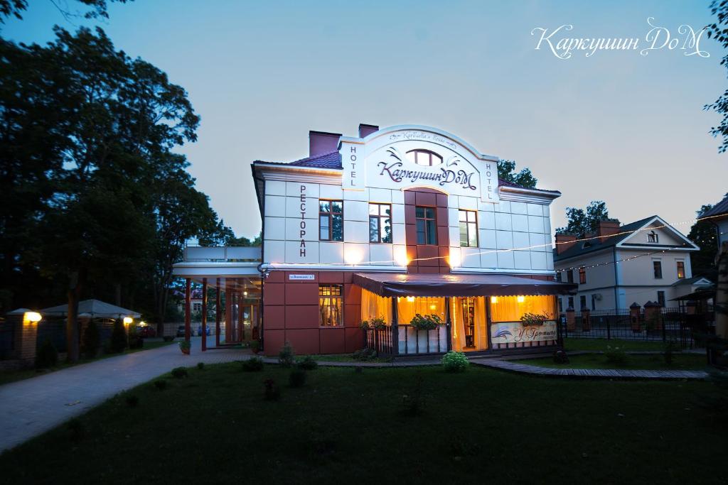 Un grand bâtiment est éclairé la nuit. dans l'établissement Karkushin Dom, à Pskov