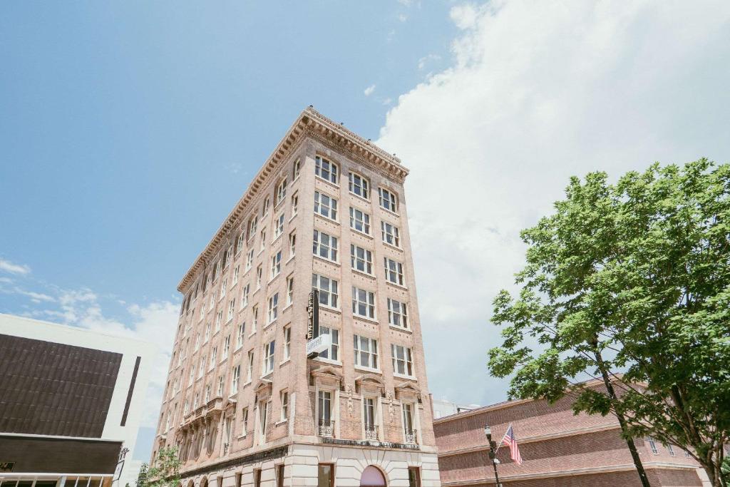 a tall stone building with a sky in the background at The Esquire Hotel Downtown Gastonia, Ascend Hotel Collection in Gastonia