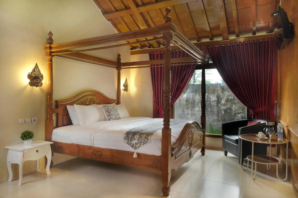 Postel nebo postele na pokoji v ubytování Kampoeng Joglo Boutique Hotel