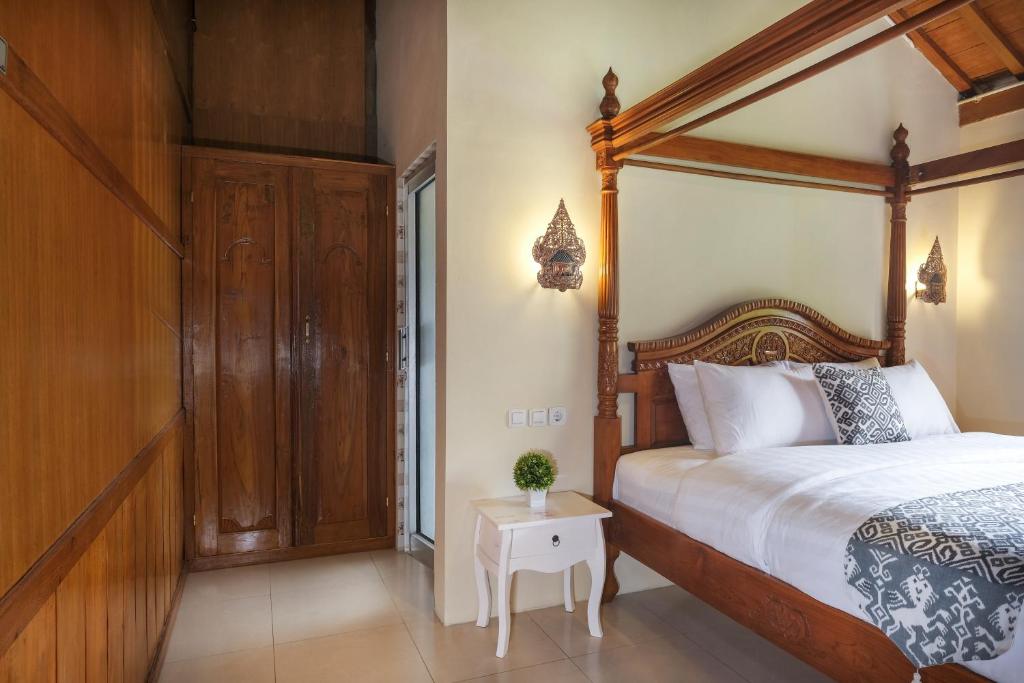 Postel nebo postele na pokoji v ubytování Kampoeng Joglo Boutique Hotel