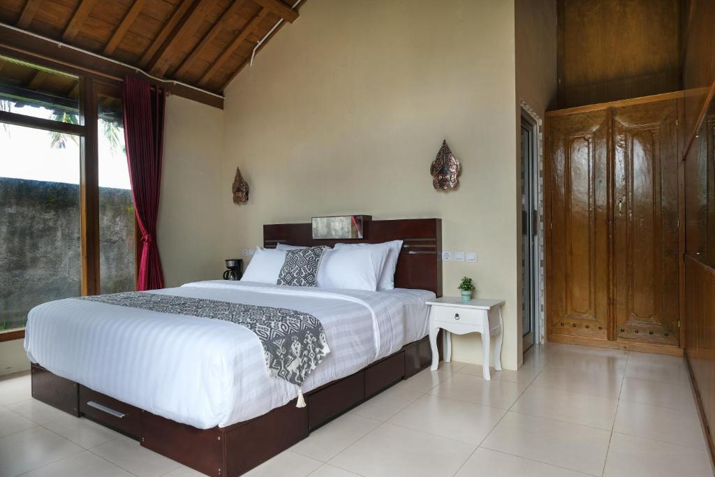 Postel nebo postele na pokoji v ubytování Kampoeng Joglo Boutique Hotel