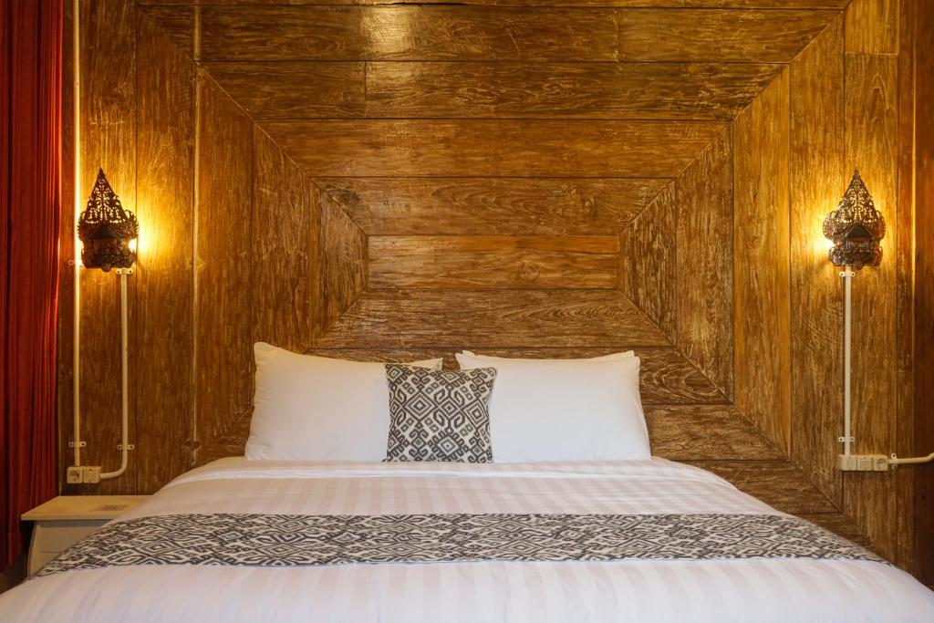 Postel nebo postele na pokoji v ubytování Kampoeng Joglo Boutique Hotel