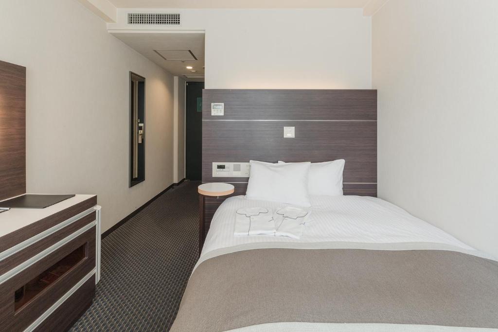 Postel nebo postele na pokoji v ubytování Kusatsu Estopia Hotel