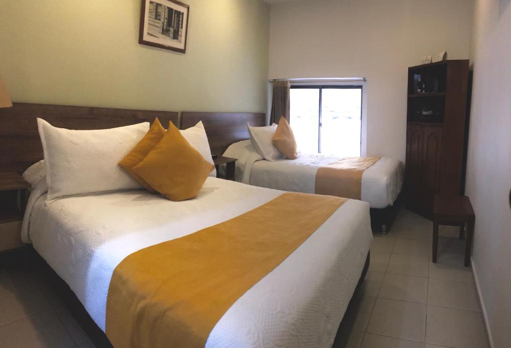 Postel nebo postele na pokoji v ubytování Hotel Ambala Bogota Colonial