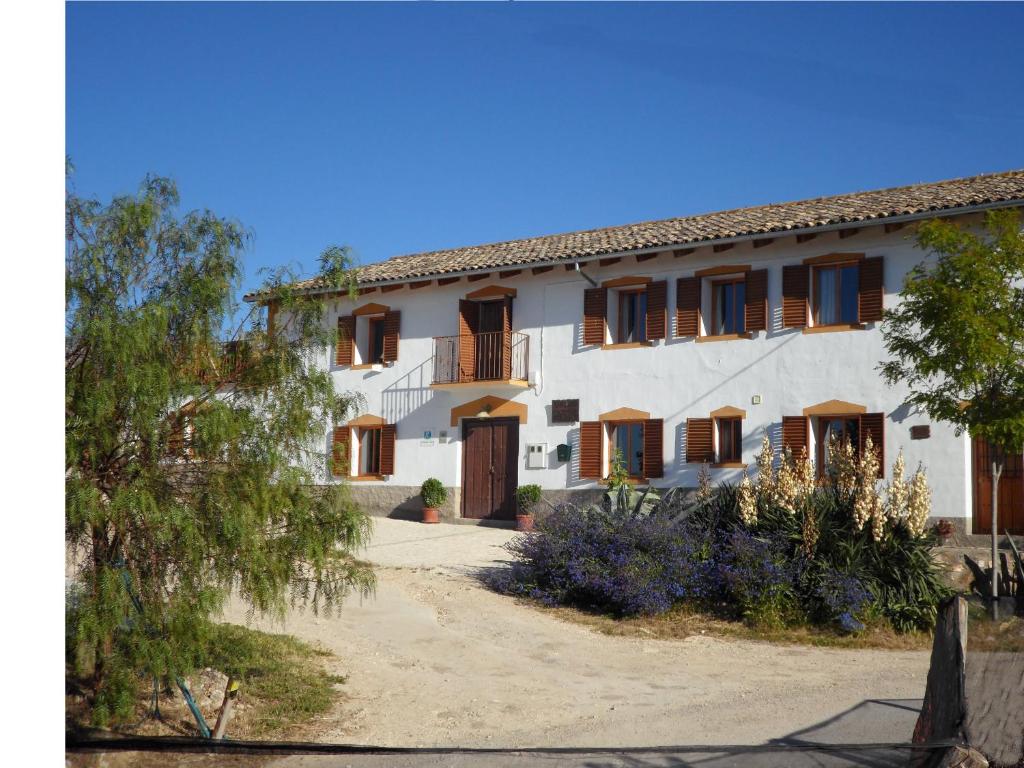 a large white building with wooden doors and windows at Cortijo Los Abedules in Cazorla