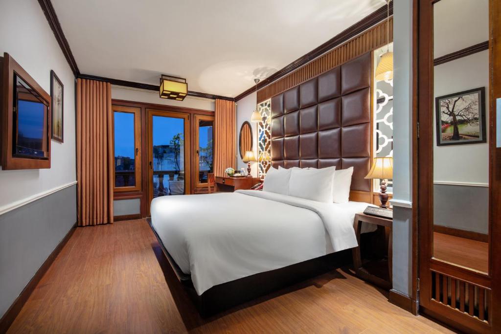um quarto com uma grande cama branca e uma janela em Classy Holiday Hotel & Spa em Hanói