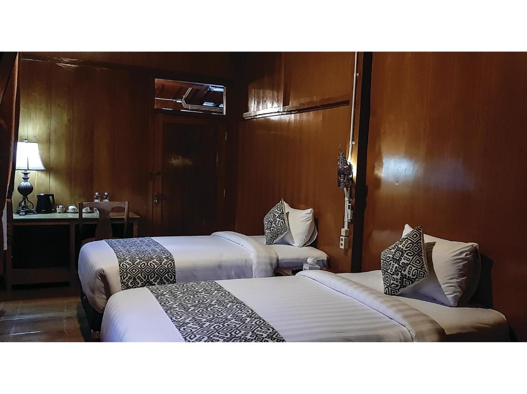 Postel nebo postele na pokoji v ubytování Kampoeng Joglo Boutique Hotel