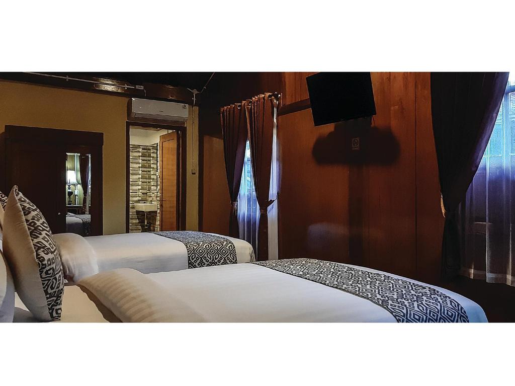 Postel nebo postele na pokoji v ubytování Kampoeng Joglo Boutique Hotel