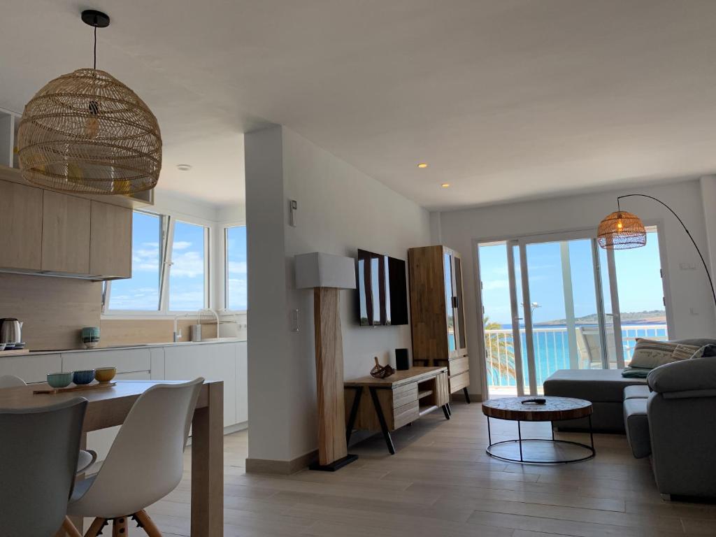 cocina y sala de estar con sofá y mesa en Sea Club Apartments, en Cala Millor