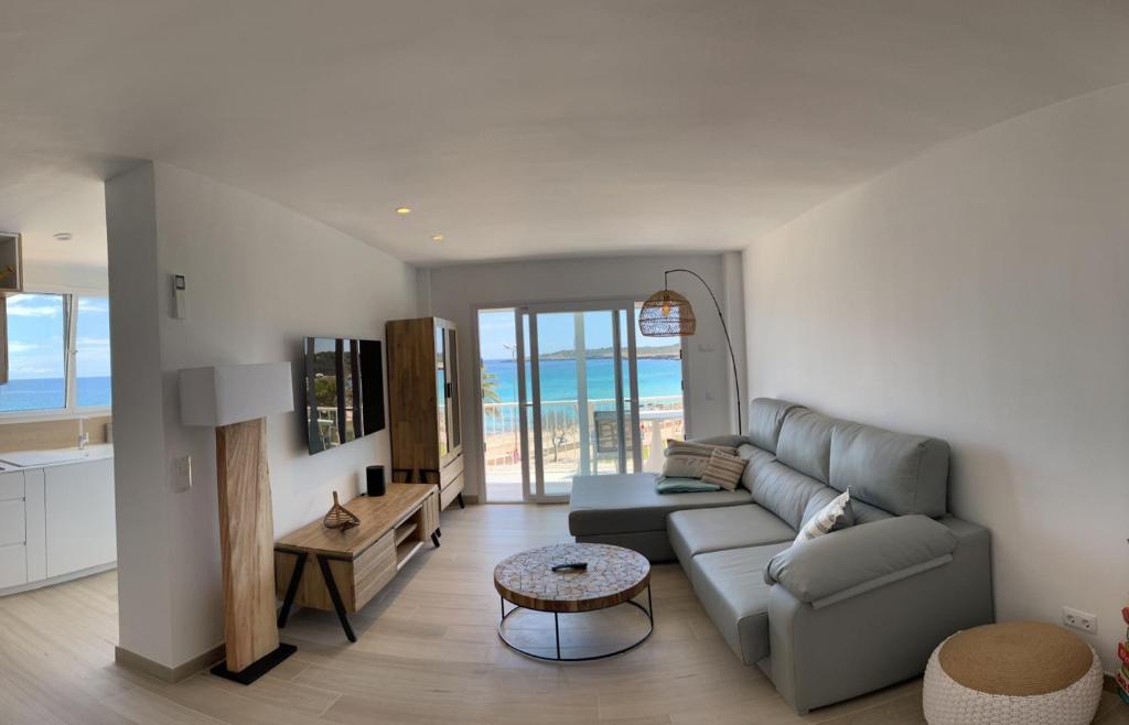 a living room with a couch and a table at Sea Club Apartments in Cala Millor