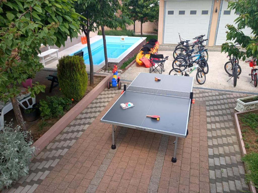 uma mesa de pingue-pongue ao lado de uma piscina em Apartment Vrljika,with private pool,bikes,garage em Imotski