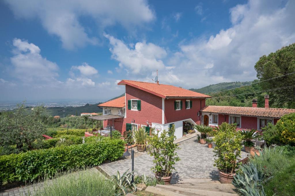 ein Haus auf einem Hügel mit Pflanzen davor in der Unterkunft B&B Rosso Baccara in Montevettolini
