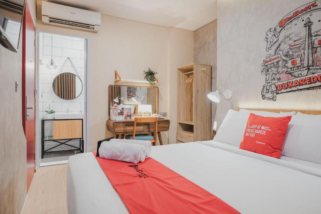 ジャカルタにあるRedDoorz Plus @ Thamrinのベッドルーム(白いベッド1台、デスク付)