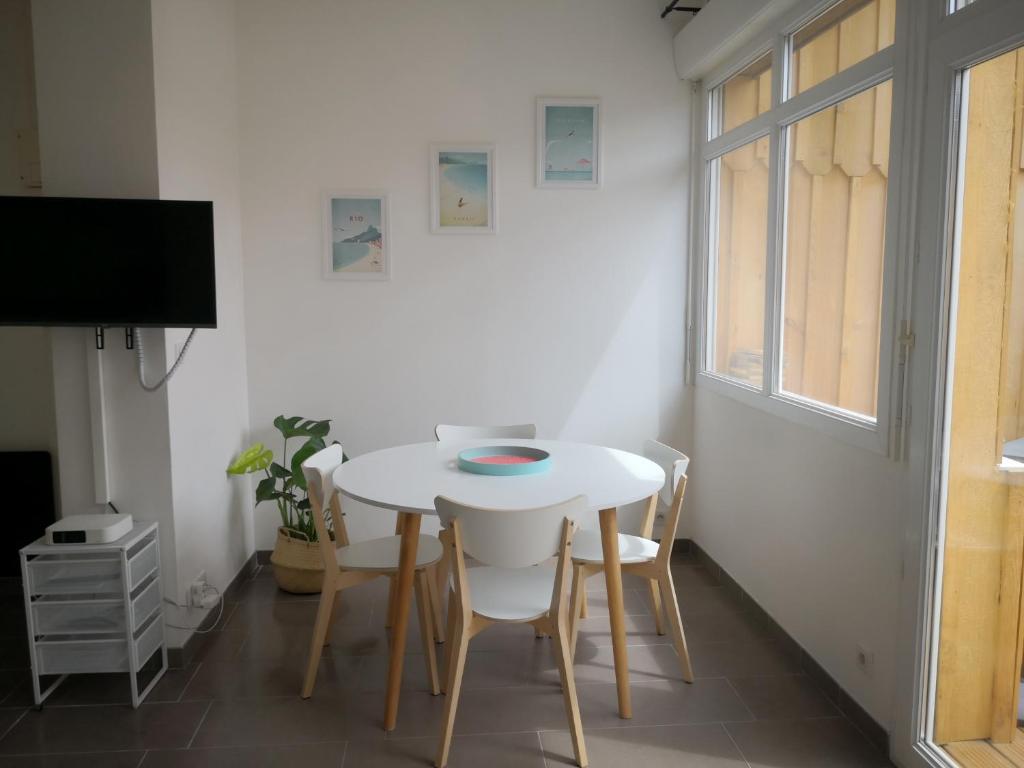 a dining room with a white table and chairs at studio en plein centre ville à 8 minutes de l'océan in Le Porge